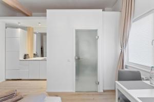 a kitchen with white walls and a sliding door at Stilvolles City-Apartment - Pfalzliebe Suites in Landau in der Pfalz +11 photos