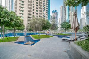 un parc avec des bancs et un parasol dans une ville dans l'établissement Bellavista - Magnificent - 3BR - 29 Boulevard - Partial Burj Khalifa & Fountain Views, à Dubaï