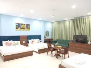 a hotel room with two beds and a television at Hà Nội Quán Homstay in Phu Quoc