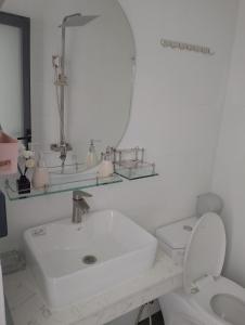 a white bathroom with a sink and a toilet at Hà Nội Quán Homstay in Phu Quoc
