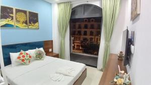 a room with a white bed and a window at Hà Nội Quán Homstay in Phu Quoc