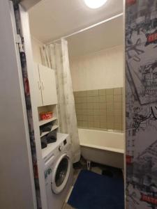 a small bathroom with a washing machine and a shower at Salaspils Apartament 2023 in Salaspils