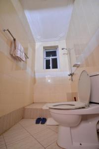 a bathroom with a toilet and a tub and a window at JEVINE HOTEL in Kampala