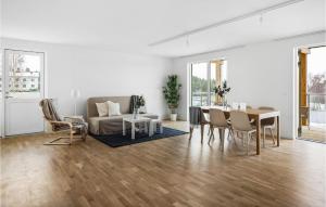 een witte woonkamer met een tafel en een bank bij Stunning Apartment In Stjrnhov With House Sea View in Stjärnhov