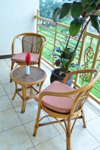 two chairs and a table with a vase on a balcony at JEVINE HOTEL in Kampala