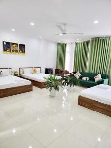 a living room with two beds and a couch at Hà Nội Quán Homstay in Phu Quoc