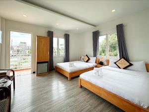 a hotel room with two beds and a large window at The Cherry Hill Hotel in Xuan An