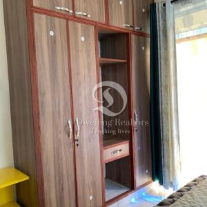 モンバサにあるBamburi comfy & luxurious homeの木製のキャビネット(ガラスドア付)