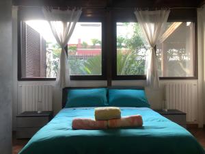 um quarto com uma cama azul e 2 janelas em Sea breeze Villa - Luna apartment em Bari Palese