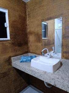 a bathroom with a white sink and a mirror at Pousada Alto da Marina in Búzios