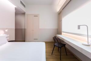 a bedroom with a bed and a desk and a chair at Hotel Terrassa Confort in Terrassa