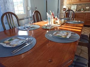 a wooden table with plates and wine glasses on it at Family apartments "Hamster" up to 7 persons in Zgornja Polskava