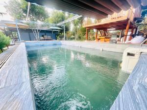 una piscina de agua frente a una casa en Mongo Garden Đà Lạt en Dalat