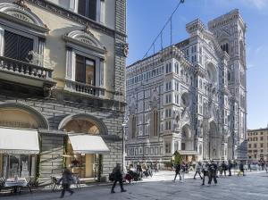 een groep mensen die op straat voor gebouwen lopen bij Gioiello Fiorentino - Duomo 2 minuti a piedi in Florence