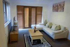 a living room with a white couch and a table at Home in Rugby Warwickshire 