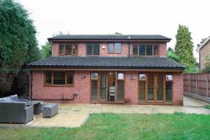 a brick house with a patio in a yard at Home in Rugby Warwickshire 