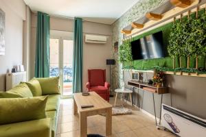 a living room with a couch and a tv at GPX-CLR TheGreenFamilySuite in Larisa