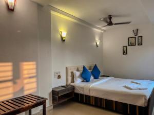 sypialnia z łóżkiem z niebieskimi poduszkami w obiekcie LA Costa Residency w mieście Anjuna