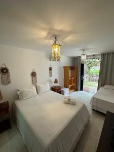 a bedroom with two beds and a chandelier at Vila do Coco - Milagres AL in São Miguel dos Milagres