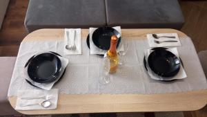einen Tisch mit zwei Tellern und einer Flasche darauf. in der Unterkunft Студио Еми in Tschepelare