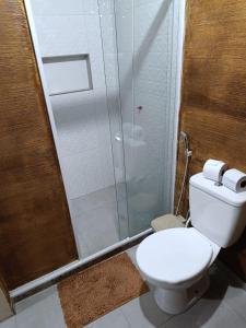 a bathroom with a toilet and a glass shower at Pousada Alto da Marina in Búzios
