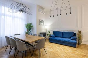 uma sala de estar com um sofá azul e uma mesa em Luxurious Central 4BEDRM 3BATHRM Residence w/ Balcony em Budapeste