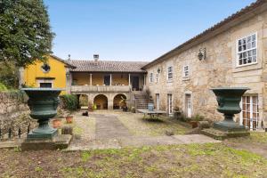 Fontoura的住宿－Quinta de San Antonio，一座古老的石头建筑,庭院里有两个台阶