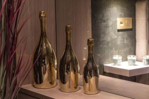 drei Flaschen Wein auf einem Regal in der Unterkunft SuiteDreams - Bali Suite Liège in Lüttich