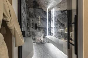 a bathroom with a sink and a stone wall at SuiteDreams - Bali Suite Liège in Liège