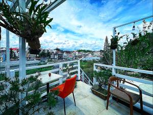 a balcony with a table and chairs and plants at The Cherry Hill Hotel in Xuan An