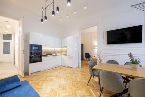 Il comprend un salon avec une table à manger et une cuisine. dans l'établissement Luxurious Central 4BEDRM 3BATHRM Residence w/ Balcony, à Budapest