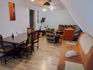 a living room with a couch and a table and chairs at Apartmány u Martina in Javorník