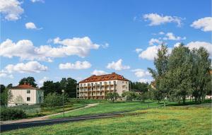 un grand bâtiment dans un champ à côté d'un bâtiment dans l'établissement Stunning Apartment In Stjrnhov With House Sea View, à Stjärnhov