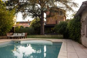 a swimming pool with a table and chairs next to a house at B&B La Maison de Julia in Albi