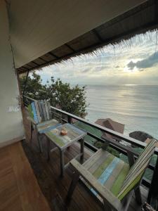 a porch with chairs and a table and the ocean at Suncliff Resort in Haad Rin