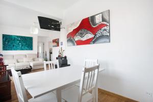 - un salon avec une table et des chaises blanches dans l'établissement Apartamento da Alegria, à Caldas da Rainha
