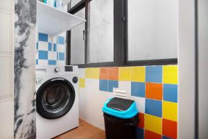 - un lave-linge dans une salle de bains dotée d'un mur coloré dans l'établissement Apartamento da Alegria, à Caldas da Rainha