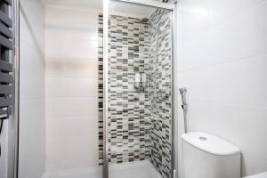 a white bathroom with a shower and a toilet at Casinha Da Vila Turcifal in Turcifal +15 photos