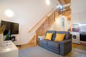 a living room with a couch and a staircase at Casinha Da Vila Turcifal in Turcifal