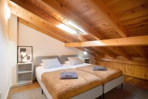 a large bed in a room with wooden ceilings at Casinha Da Vila Turcifal in Turcifal