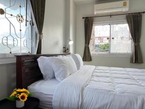 a white bed in a bedroom with a window at BAAN OZONE HY2 in Hat Yai