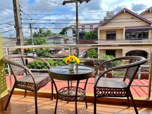 a balcony with two chairs and a table with flowers at BAAN OZONE HY2 in Hat Yai