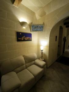 uma sala de estar com um sofá e um candeeiro em Il figolla b&b em Xaghra