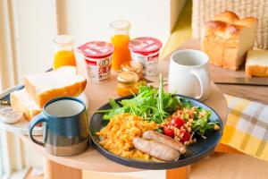 a table with a plate of breakfast food on a table at KAMOME SLOW HOTEL the COMPACT in Awaji