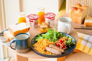 una mesa con un plato de desayuno en una mesa en KAMOME SLOW HOTEL the COMPACT, en Awaji