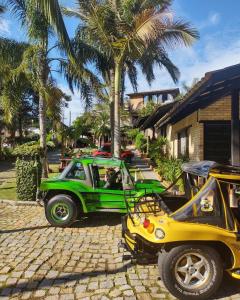a green jeep parked next to a palm tree at Chalés do Holandês Eco Pousada in Bombinhas