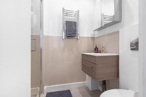 a bathroom with a toilet and a sink and a shower at Quaint Mews Home in Chelsea in London