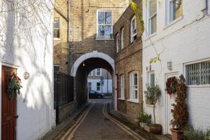 an alley with an archway in a brick building at Quaint Mews Home in Chelsea in London