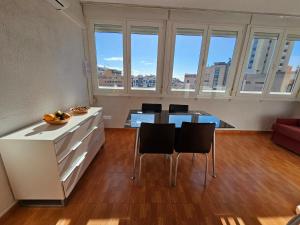 een keuken met een aanrecht en stoelen in een kamer met ramen bij Apartamento Edificio Florida in Benidorm