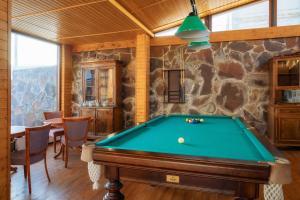 a pool table in a room with a stone wall at Hotel GoodAura in Gudauri